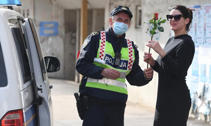A police officer stops a female driver and gives her a red rose on the occasion of International Women's Day in Sibenik, Croatia, March 8, 2021.Photo:Xinhua