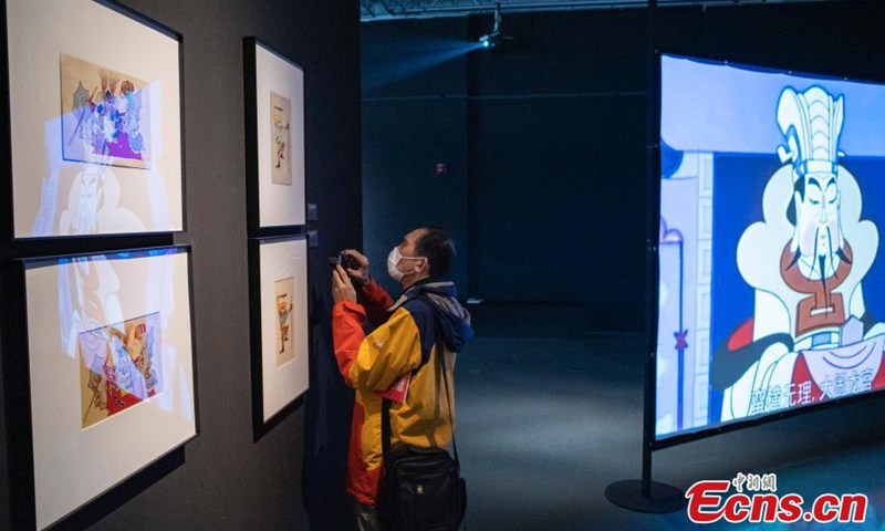 2021年3月9日，在北京嘉德艺术中心的一次艺术展览中，一位游客看着一个漫画骑士的雕塑图片：中国新闻社