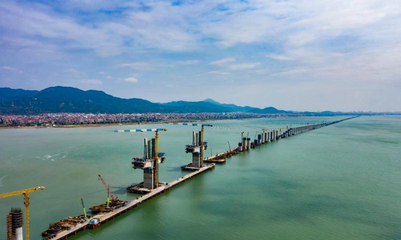 Aerial photo taken on March 10, 2021 shows the construction site of Meizhou Bay cross-sea bridge of the Fuzhou-Xiamen high-speed railway in southeast China's Fujian Province. Main towers of the bridge have been topped off on Wednesday. The 14.7-km-long bridge is part of the province's Fuzhou-Xiamen high-speed railway, which is expected to be put into operation in 2022.Photo:Xinhua