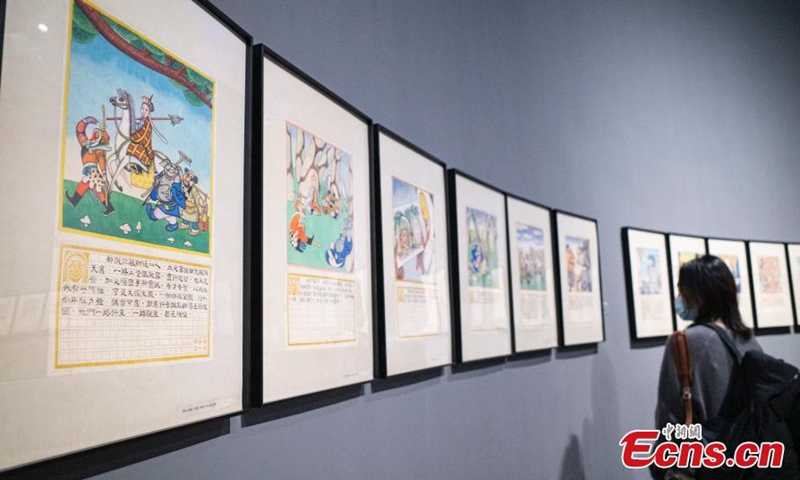 2021年3月9日，在北京嘉德艺术中心的一次艺术展览中，一位游客看着一个漫画骑士的雕塑图片：中国新闻社