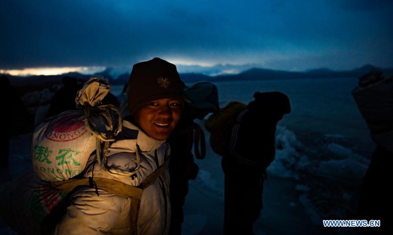 Villagers prepare to spread cow dung and stove ashes to make a safe path on the frozen Puma Yumco Lake, southwest China's Tibet Autonomous Region, March 6, 2021.Photo:Xinhua