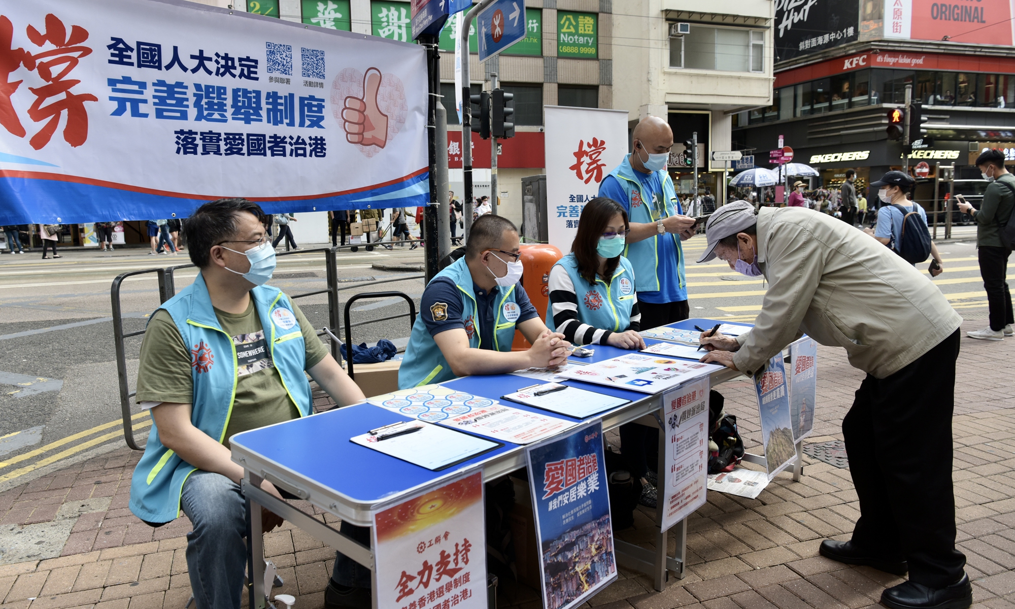 Hong Kong residents sign their names at Wan Chai Street Station in support of the National People's Congress decision to improve the Hong Kong electoral system and ensure 