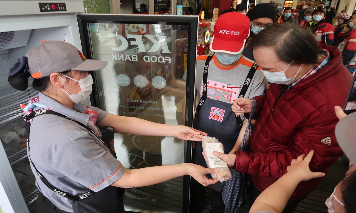 Photo: A KFC staff gives food to resdients queuing up at a KFC food bank in Yangpu district, Shanghai. Photo: VCG