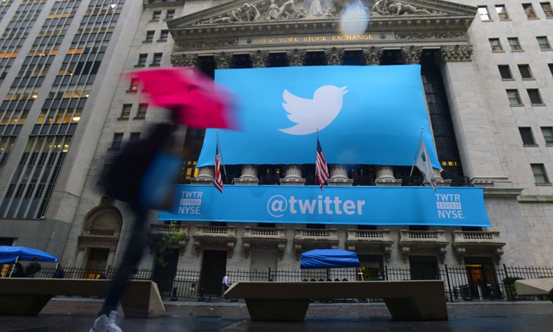 Pedestrians pass by a giant logo of Twitter hanging on the front gate of the New York Stock Exchange in New York, U.S., Nov. 7, 2013. (Photo: Xinhua)