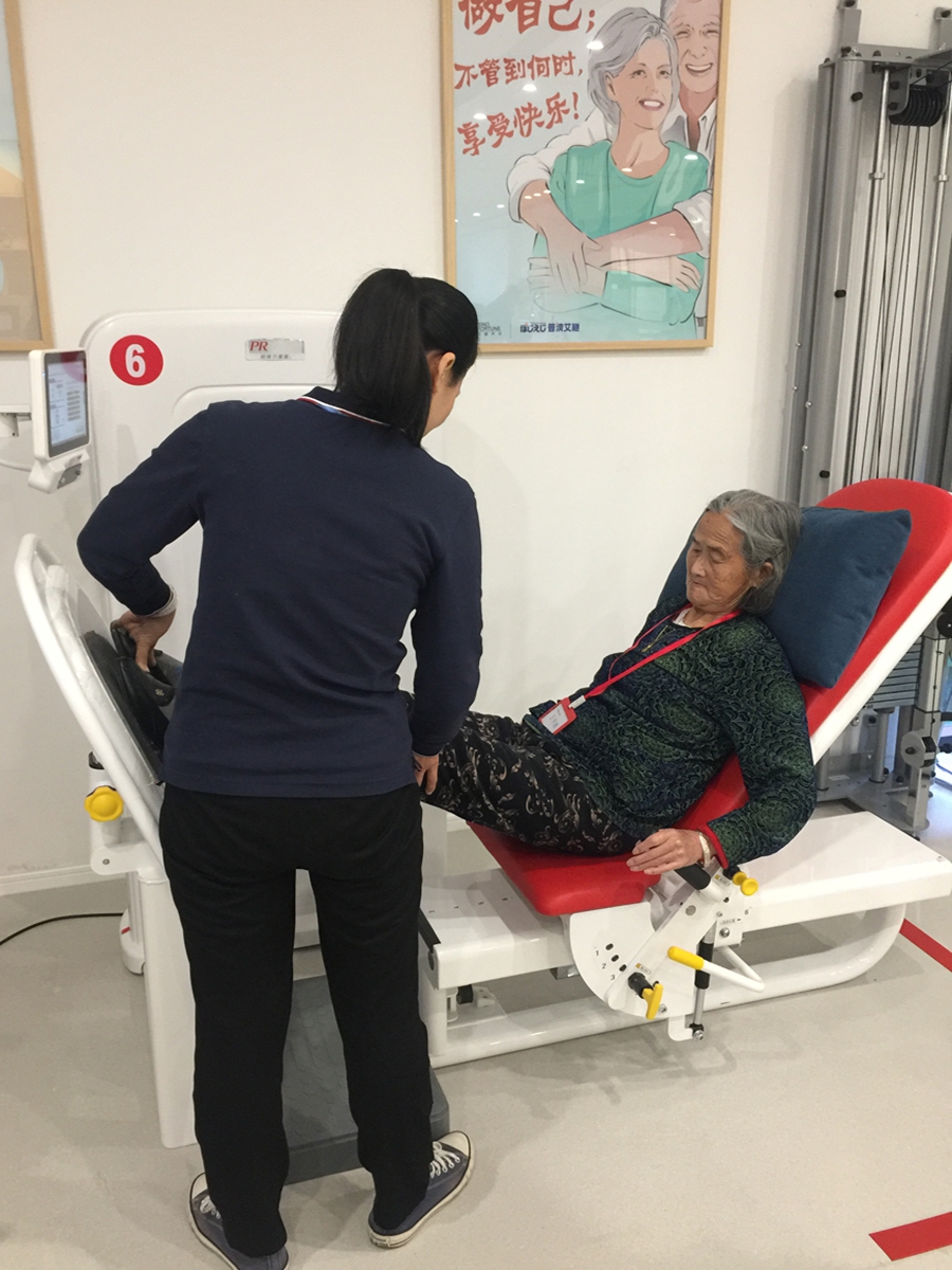 A physical therapist instructs a woman doing leg workouts in a 