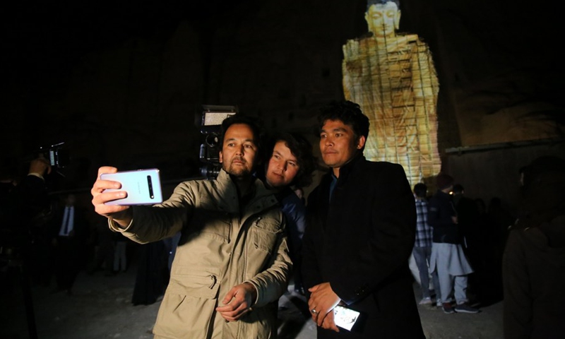 People take selfies during an event of the 20th anniversary of the Buddha destruction in Bamyan province, Afghanistan, March 9, 2021.(Photo: Xinhua)