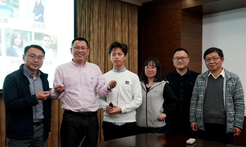 Macromolecular science professor Peng Huisheng (2nd L) of Fudan University poses for photos with his research team in Shanghai, east China, March 10, 2021.(Photo:Xinhua) 