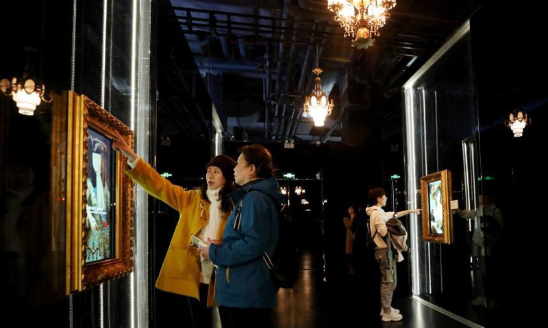 Visitors experience an interactive game of changing faces for a painting of the Versailles palace during an exhibition in Shanghai, east China, March 12, 2021. A China itinerant exhibition of Versailles palace is held at Xintiandi commercial complex in Shanghai, during which digital technologies and interactive activities offer people the unique experience of visiting the palace. Photo:Xinhua