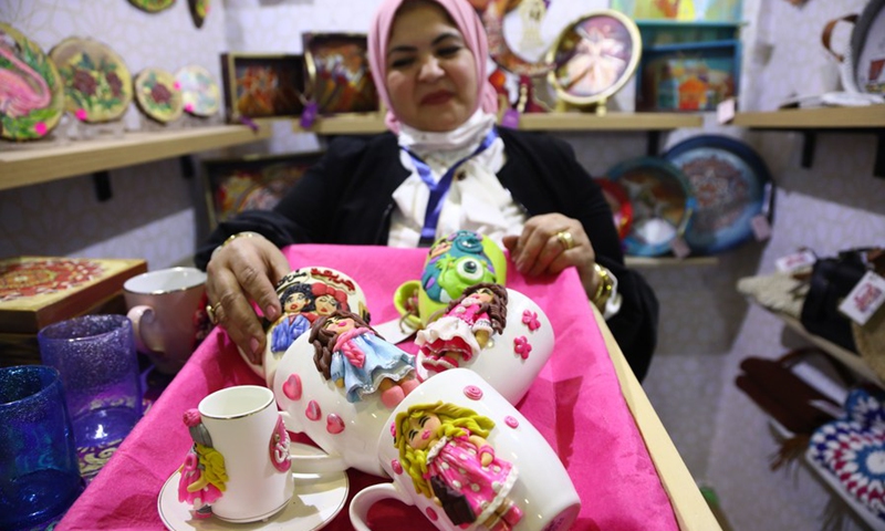 An exhibitor shows handicrafts at her stall during the Bazaar exhibition in Cairo, Egypt, on March 11, 2021.(Photo: Xinhua)