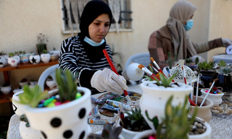 Lubna Al-Fakyat (L) and her sister Amal (R) display their work at their home in the West Bank city of Hebron on March 13, 2021.(Photo: Xinhua)