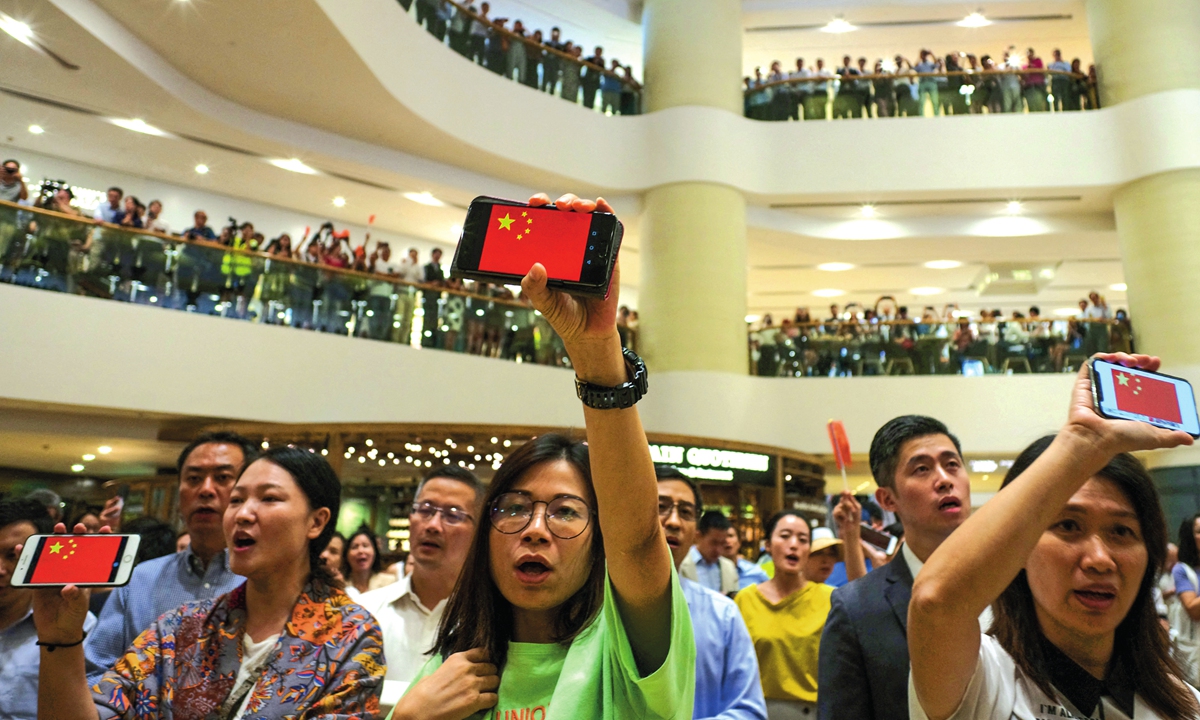People in Hong Kong show their support to the government by holding up their phone screens displaying the Chinese national flag in a flash mob in September 2019. Photo: AFP
