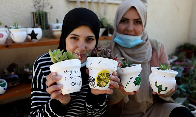 Lubna Al-Fakyat (L) and her sister Amal (R) display their work at their home in the West Bank city of Hebron on March 13, 2021.(Photo: Xinhua)