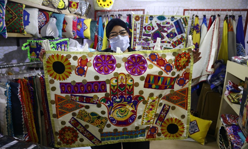 An exhibitor shows a handicraft at her stall during the Bazaar exihbition in Cairo, Egypt, on March 11, 2021.(Photo: Xinhua)