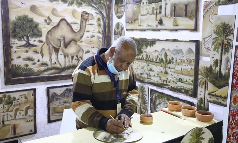 An exhibitor works at his stall during the Bazaar exhibition in Cairo, Egypt, on March 11, 2021.(Photo: Xinhua)