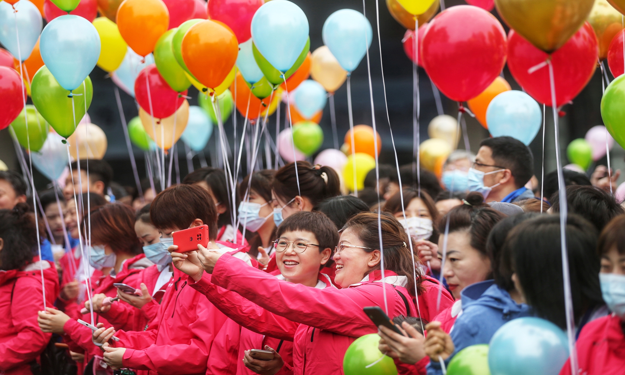 A group of medics take selfies in Wuhan on Sunday. As oriental cherries are in full blossom in Wuhan, more than 3,000 medical personnel who assisted Wuhan in the fight against COVID-19 in early 2020 return to the city along with their families as the guests of the city, where they visit Wuhan University,  believed to be one of the best places in China to enjoy the flowers to enjoy. Photo: Cui Meng/GT