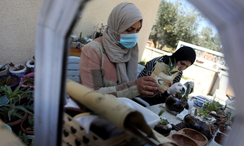 Lubna Al-Fakyat (L) and her sister Amal (R) display their work at their home in the West Bank city of Hebron on March 13, 2021.(Photo: Xinhua)