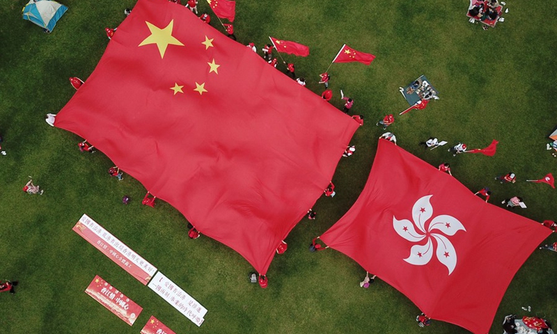Aerial photo taken on March 6, 2021 shows people displaying China's national flag and the flag of the Hong Kong Special Administrative Region in support of implementing the principle of patriots administering Hong Kong at Tamar Park in Hong Kong, south China.(Photo: Xinhua)