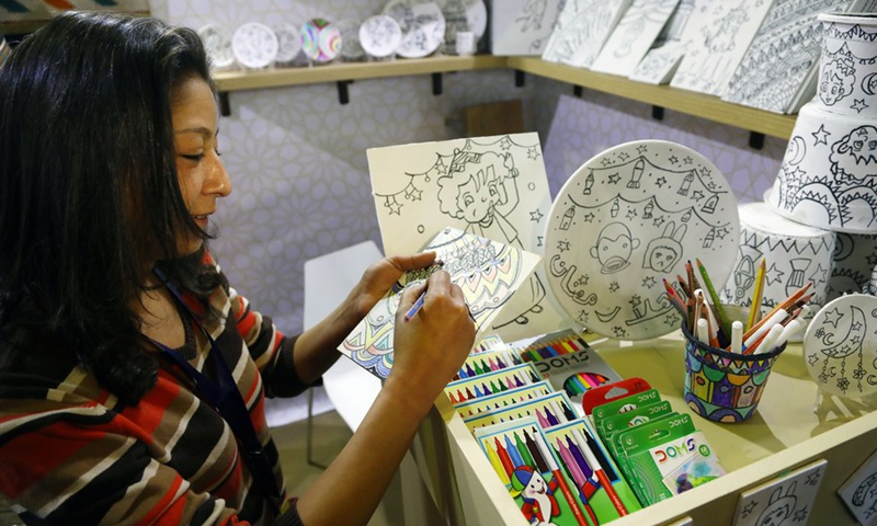 An exhibitor works at her stall during the Bazaar exhibition in Cairo, Egypt, on March 11, 2021.(Photo: Xinhua)