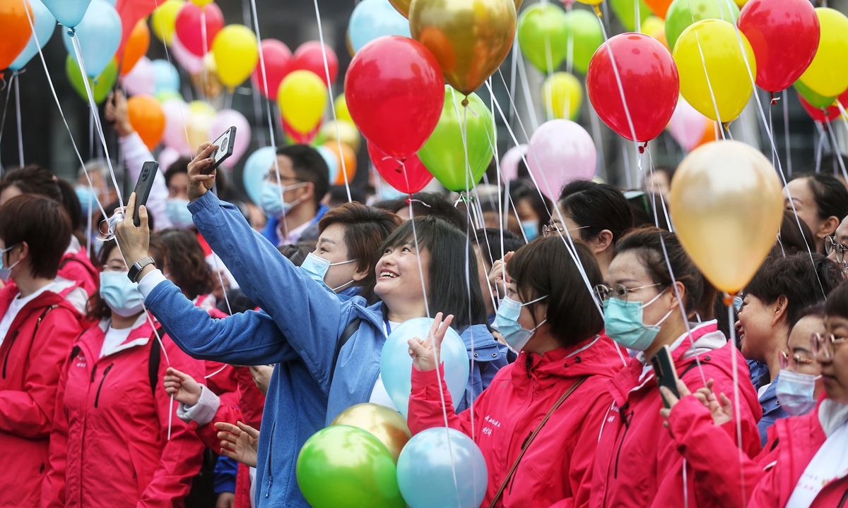 A young medical worker takes&nbsp;her child to enjoy the&nbsp;beautiful&nbsp;scenery under the blooming cherry trees at Wuhan University&nbsp;on Saturday. Photo: Cui Meng/GT