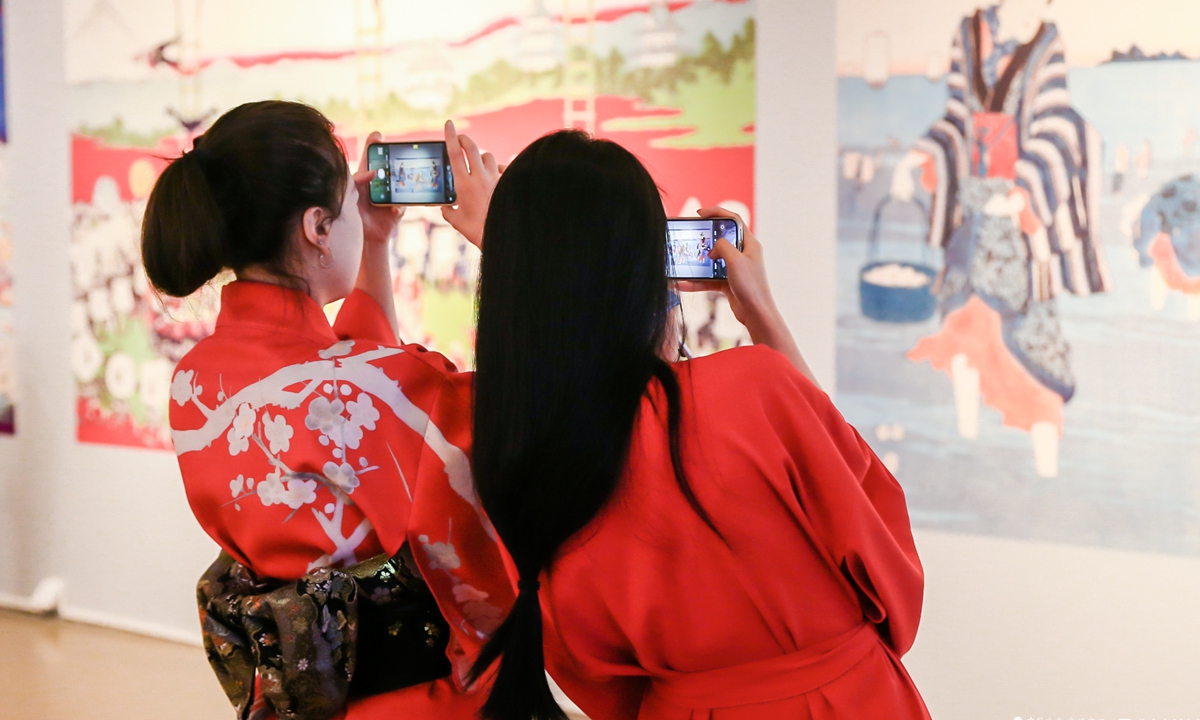 Two visitors take photos of <em>The Meeting Ukiyo-e: a Floating World of Edo City</em> exhibition in Beijing on Friday. Photo: Courtesy of Chang Jing 