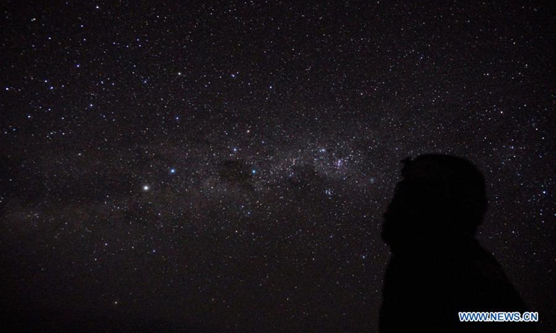 Photo taken on March 15, 2021 shows a man standing in the starry night during the Nyepi Day, or the Day of Silence, at Denpasar, Bali, Indonesia. Nyepi marks the New Year day of the Balinese Saka calendar in Indonesia. On this public holiday, locals devote themselves to fasting and meditation, while refraining from practices such as lighting fires, working, traveling and entertaining.Photo:Xinhua