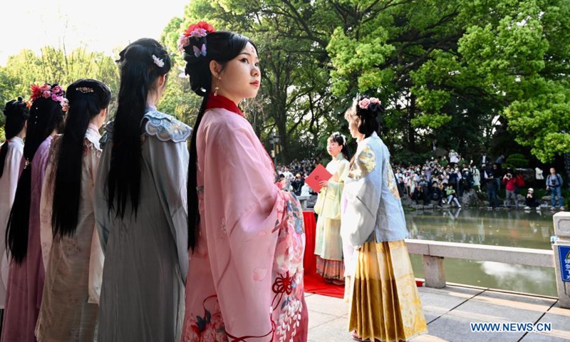 Women in traditional costumes celebrate Hua Zhao Jie, or the traditional Flower Festival, at the West Lake Park in Fuzhou, southeast China's Fujian Province, March 14, 2021. A series of activities, such as offering sacrifice to the spring flowers, are held to celebrate the festival in Fuzhou on March 13-14.(Photo: Xinhua)