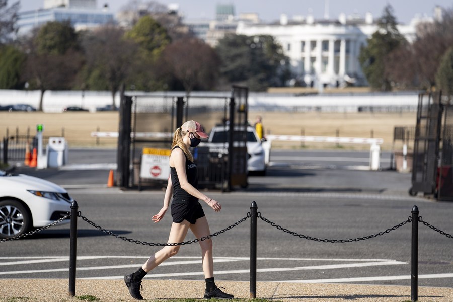 A woman wearing a face mask walks past the White House in Washington, D.C., the United States, March 11, 2021.(Photo: Xinhua)