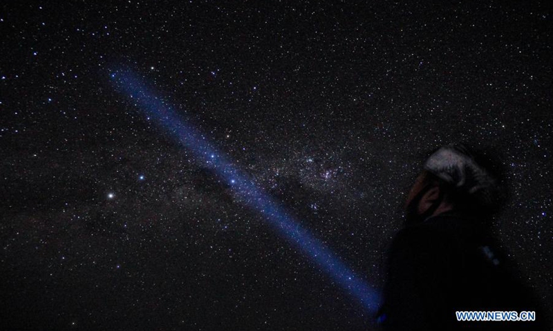 Photo taken on March 15, 2021 shows a man standing in the starry night during the Nyepi Day, or the Day of Silence, at Denpasar, Bali, Indonesia. Nyepi marks the New Year day of the Balinese Saka calendar in Indonesia. On this public holiday, locals devote themselves to fasting and meditation, while refraining from practices such as lighting fires, working, traveling and entertaining.Photo:Xinhua