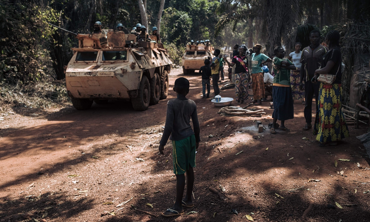 Families displaced from the conflict watch as a convoy of Moroccan peacekeepers from the United Nations Integrated Multidimensional Stabilization Mission in the Central African Republic (MINUSCA) passes by on the outskirts of Bangassou on February 3. Photo: VCG