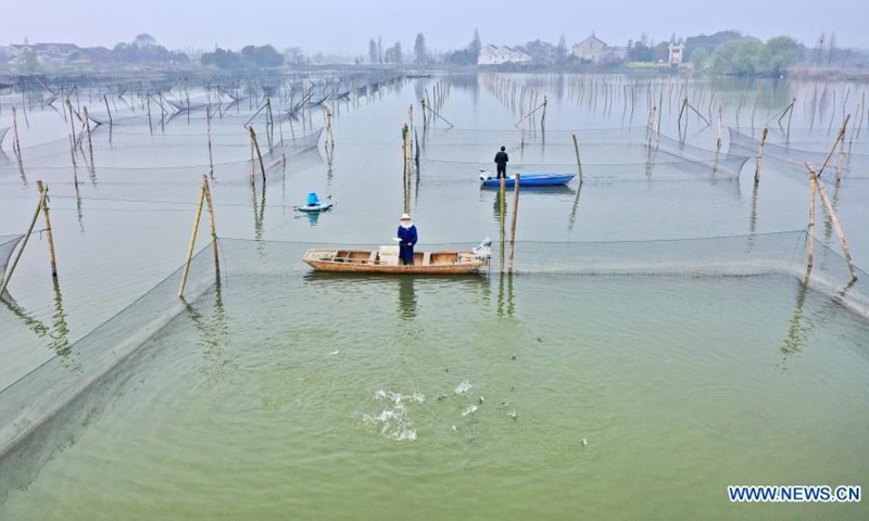Aerial photo taken on March 14, 2021 shows farmers feeding basses in Deqing County of Huzhou City, east China's Zhejiang Province.(Photo: Xinhua)