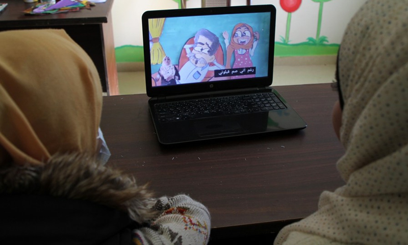 Palestinian women with hearing impairment watch a cartoon at Youths' Mettle institution in al-Mughazi refugee camp in the central Gaza Strip on March 7, 2021.(Photo: Xinhua)
