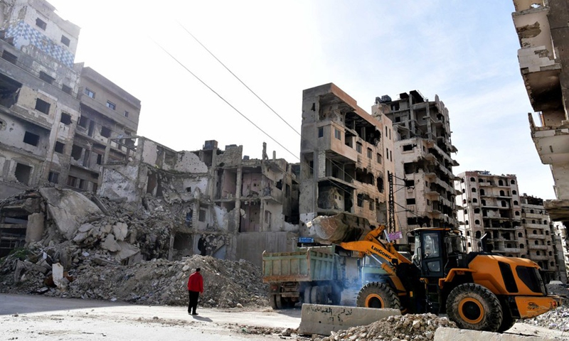 Workers remove the rubble from a shattered area in old Homs city in central Syria, March 11, 2021.(Photo: Xinhua)