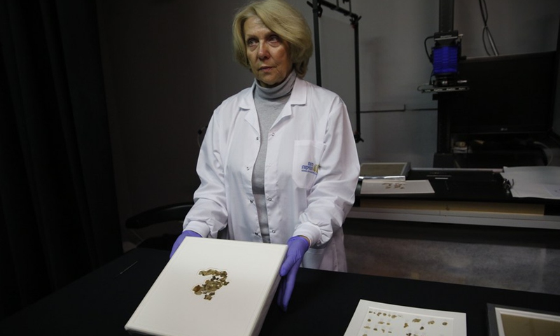 A staff member shows fragments of the new discovered Dead Sea Scroll in a lab in the Israel Museum in Jerusalem on March 16, 2021.(Photo: Xinhua)