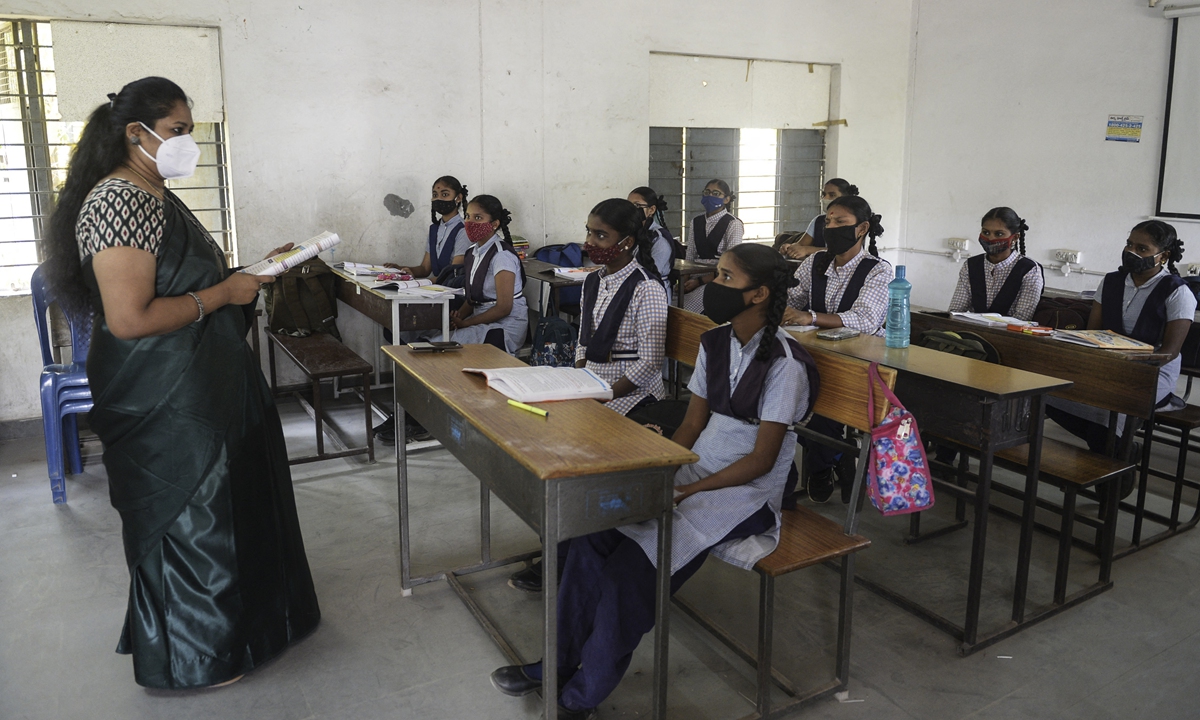 Students wearing face masks maintain social distance while attending class at a government girls high school amid the ongoing COVID-19 pandemic in Hyderabad, India on Wednesday. The country's daily coronavirus infections jumped by 28,903 on Wednesday, data from the health ministry showed, for the highest increase since December 13 and taking the nationwide tally to 11.44 million. Photo: AFP