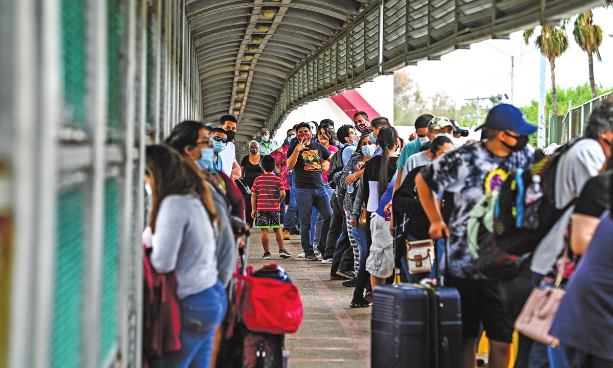 Migrants mostly from Central America wait in line to cross the border at the Gateway International Bridge from Matamoros, Mexico to Brownsville, Texas, the US on Monday. Photo: AFP