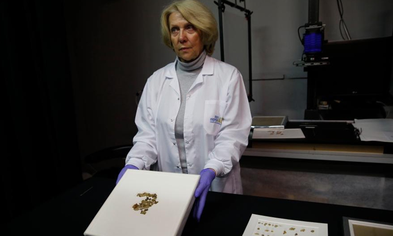 A staff member shows fragments of the new discovered Dead Sea Scroll in a lab in the Israel Museum in Jerusalem on March 16, 2021. Israeli archaeologists have discovered dozens of fragments of a biblical scroll written in Greek in the Cave of Horror near the Dead Sea.Photo:Xinhua