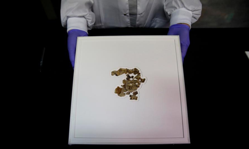 A staff member shows fragments of the new discovered Dead Sea Scroll in a lab in the Israel Museum in Jerusalem on March 16, 2021. Israeli archaeologists have discovered dozens of fragments of a biblical scroll written in Greek in the Cave of Horror near the Dead Sea.Photo:Xinhua