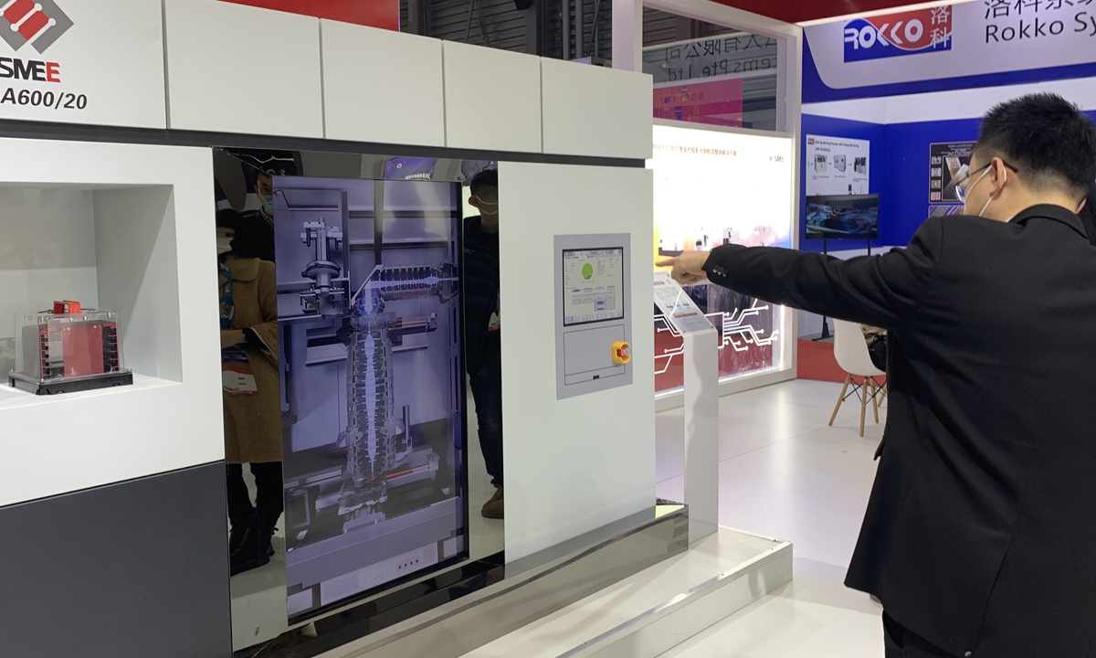 An employee with Shanghai Micro Electronics Equipment introduces scanner machine model to visitors on Thursday. Photo: Qi Xijia/GT
