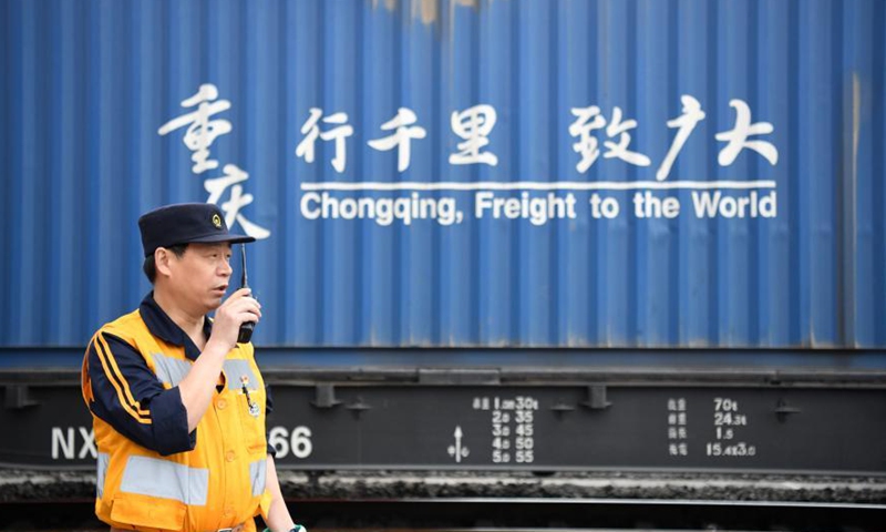 A railway staff member checks a Yuxin'ou (Chongqing-Xinjiang-Europe) China-Europe freight train before it leaves the Tuanjie Village Station of southwest China's Chongqing Municipality, March 19, 2021. Photo: Xinhua