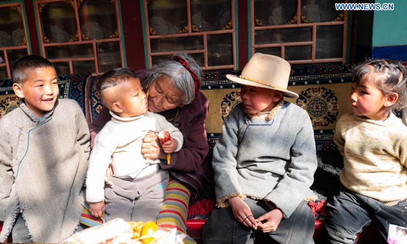Drungtok (C) enjoys time with her grandchildren at home in Xigaze, southwest China's Tibet Autonomous Region, Jan. 15, 2021.(Photo:Xinhua)