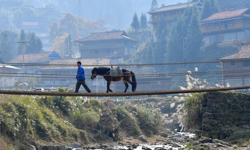 A villager walks on a newly-built iron-chain bridge in Wuying Village, a remote village inhabited by the Miao ethnic group on the border between south China's Guangxi Zhuang Autonomous Region and southwest China's Guizhou Province, Dec. 25, 2020.(Photo: Xinhua)