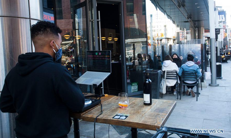 Customers dine as a DJ plays music at the outdoor area of a restaurant in Toronto, Canada, on March 20, 2021. With distancing rules and a number of other public health and workplace safety measures, outdoor dining was allowed to resume Saturday in Toronto under modifications to the Ontario's color-coded pandemic response framework. (Photo by Zou Zheng/Xinhua)