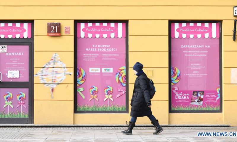 A woman wearing a face mask walks past a closed store in central Warsaw, Poland, on March 20, 2021. The government of Poland announced a new nationwide partial lockdown on Friday after the cumulative number of COVID-19 cases since the start of the pandemic exceeded two million in the country.(Photo: Xinhua)