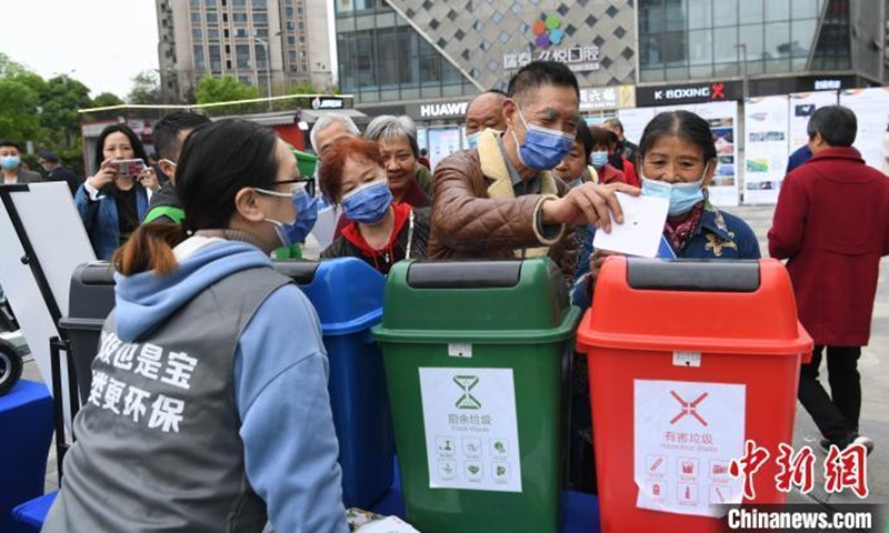 Photo taken on March 19, 2021 shows Chongqing citizens participate in a garbage sorting game. Sponsored by the Urban Management Bureau of Liangjiang New Area, Qongqing, it aims to arouse people's environmental consciousness. Participants will be awarded with gifts if they correctly sort the garbage. (Photo: China News Service/Chen Chao)
