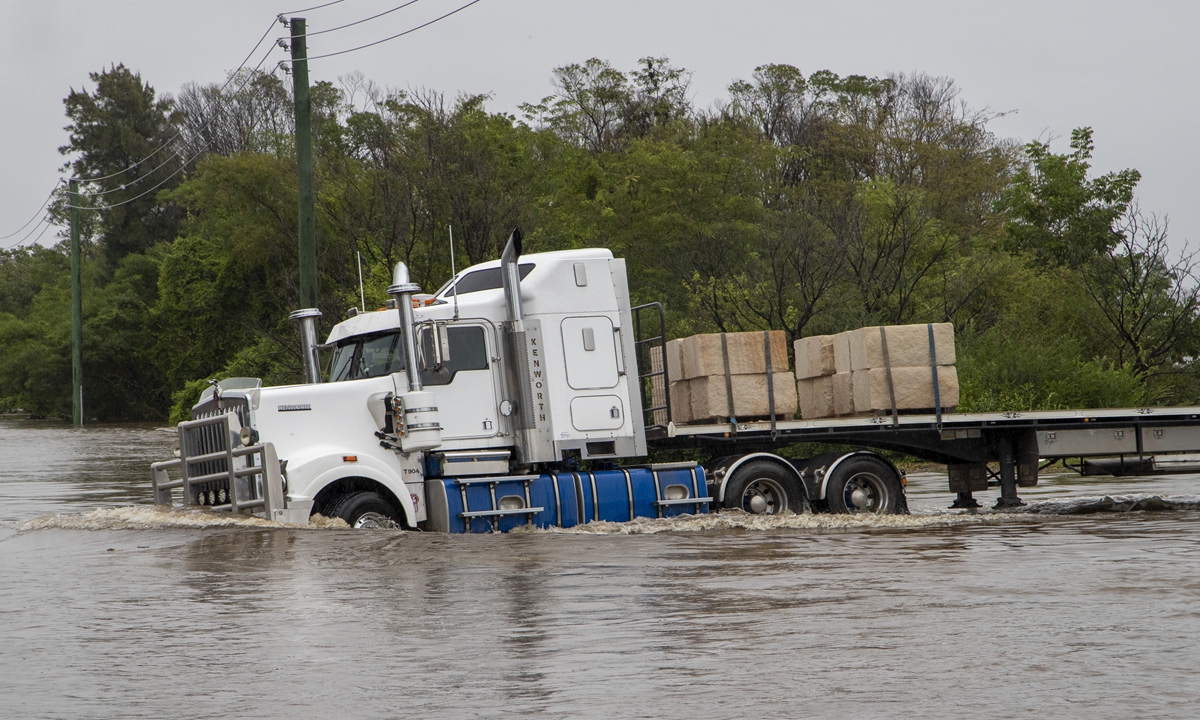A truck drives through a flooded road at Old Pitt Town north west of Sydney, Australia, Sunday. Australia's most populous state of New South Wales on Sunday issued more evacuation orders following the worst flooding in decades. Photo: AP