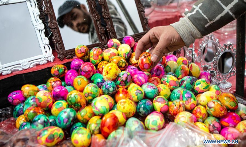 A man buys colorful eggs at a bazaar ahead of Nowruz, the Iranian New Year, in Tehran, Iran, March 18, 2021.(Photo: Xinhua)