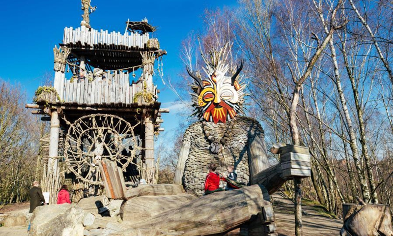 Children play around a troll at the De Schorre forest park in Boom, Belgium, March 20, 2021. Danish artist Thomas Dambo and his team built seven giant trolls from reclaimed wood at the De Schorre forest park in northern Belgium in 2019. These giant wooden sculptures are dotted around the forest.(Photo: Xinhua)