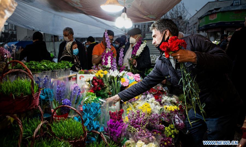 A man buys flowers at a bazaar ahead of Nowruz, the Iranian New Year, in Tehran, Iran, March 18, 2021.(Photo: Xinhua)