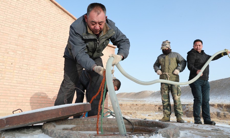 Gu Zhengli (1st L) and his colleagues install a pump at a water supply point in Dahe Township, Yugu Autonomous County of Sunan, northwest China's Gansu Province, March 20, 2021.(Photo: Xinhua)