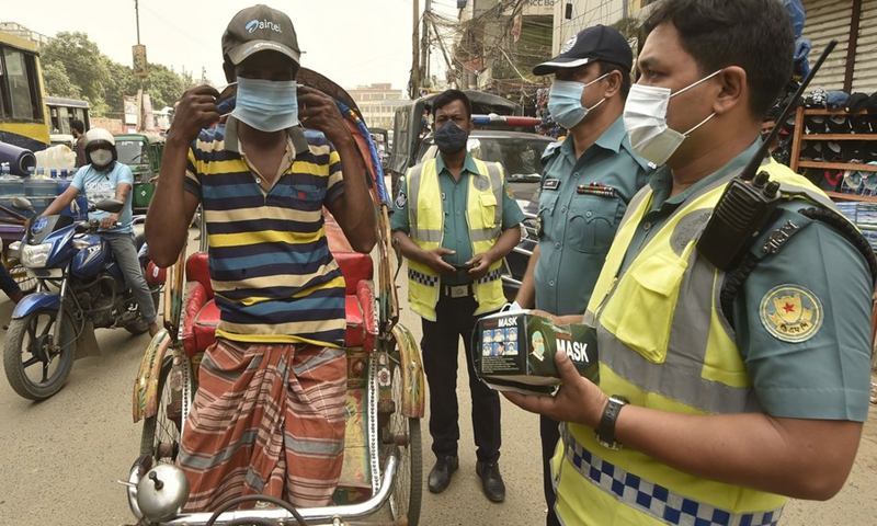 Law enforcers distribute masks in Dhaka, Bangladesh on March 21, 2021.(Photo: Xinhua)